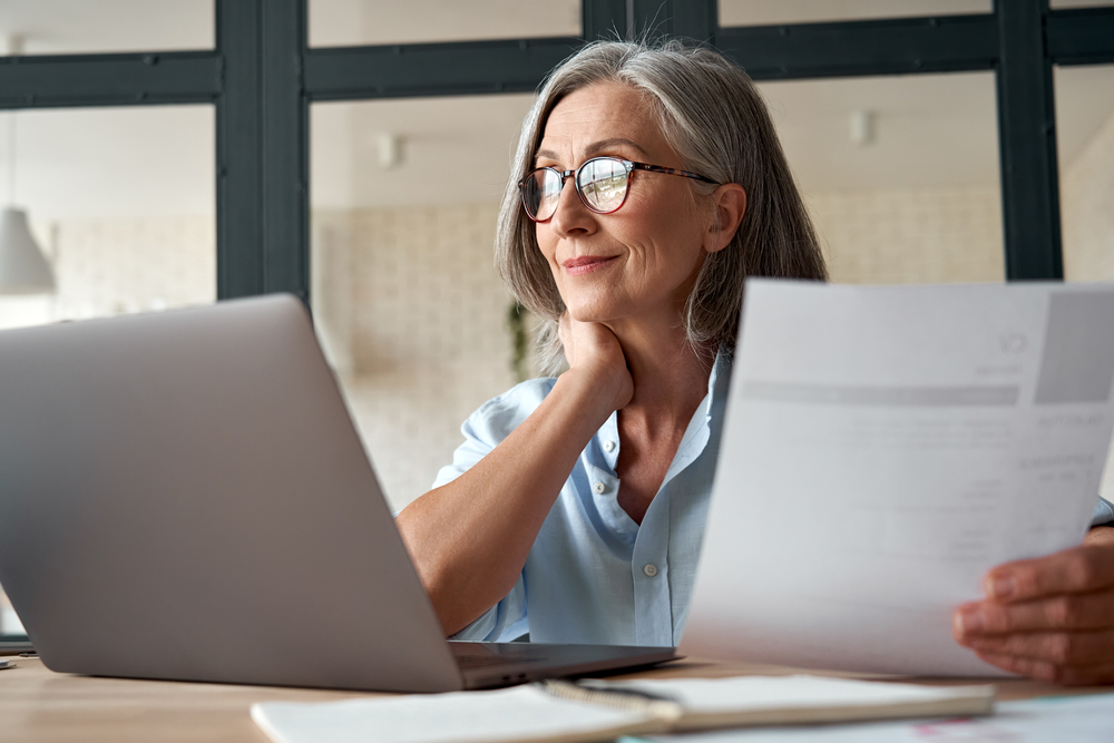 Smiling Mature Middle Aged Business Woman looking at health insurance
